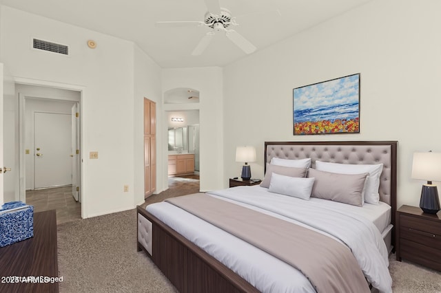 bedroom with ensuite bath, ceiling fan, and carpet