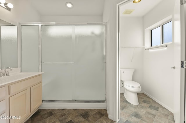 bathroom featuring a shower with door, vanity, and toilet