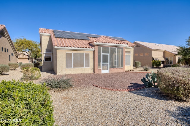 rear view of property with solar panels