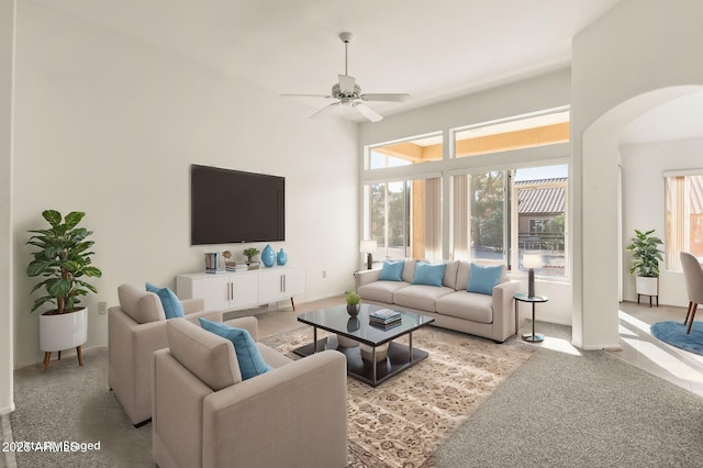 living room with ceiling fan, light carpet, and plenty of natural light