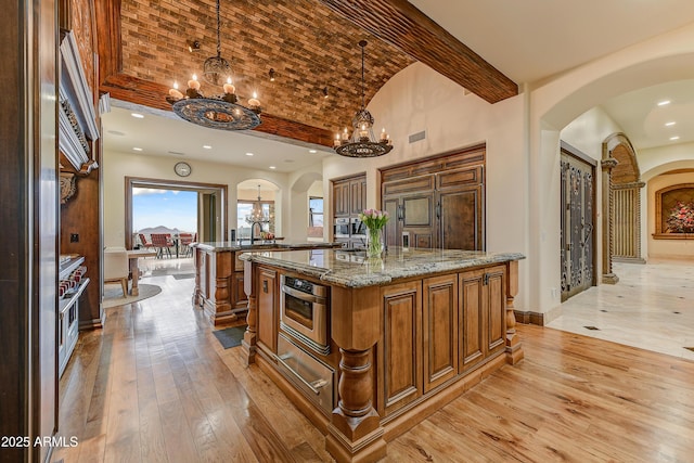 kitchen with brick ceiling, a chandelier, arched walkways, and oven