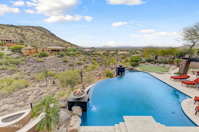 outdoor pool featuring a patio and a mountain view