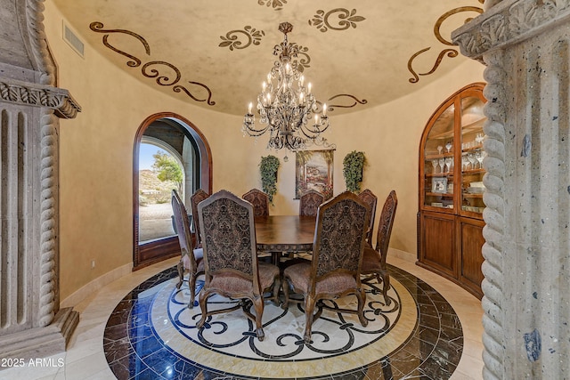 dining area featuring arched walkways, marble finish floor, a notable chandelier, visible vents, and baseboards