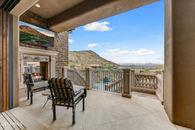 view of patio featuring a balcony and a mountain view