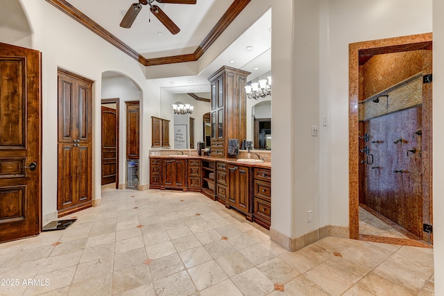 bathroom featuring ornamental molding, a sink, and a shower stall