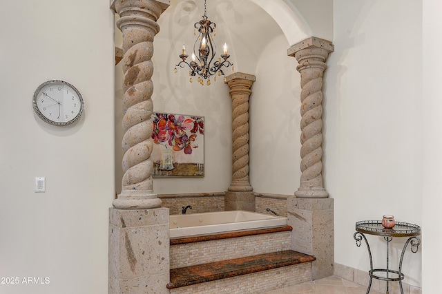 bathroom featuring ornate columns, a chandelier, a bath, and tile patterned floors