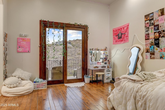 bedroom with access to outside and hardwood / wood-style flooring