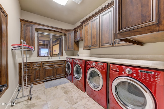 laundry area with washing machine and dryer, cabinet space, and a sink