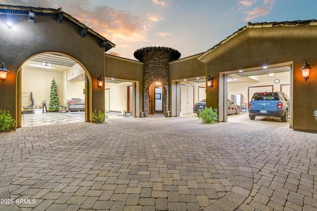 exterior space featuring decorative driveway and stucco siding