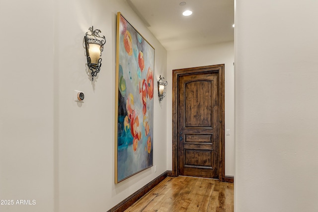 hall featuring recessed lighting, light wood-style flooring, and baseboards