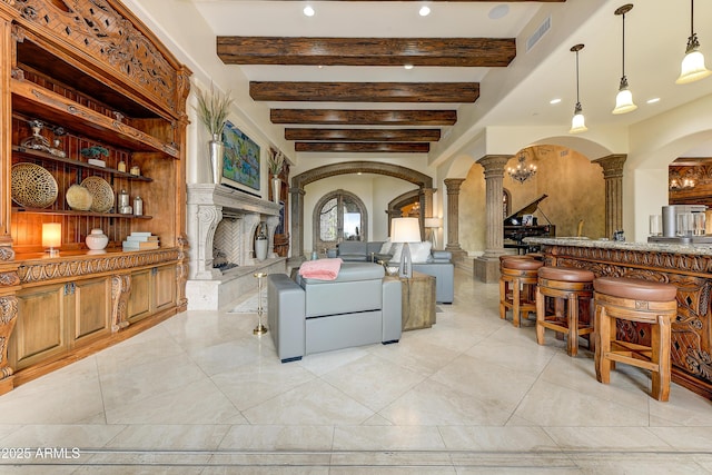 interior space featuring arched walkways, a high end fireplace, visible vents, and ornate columns