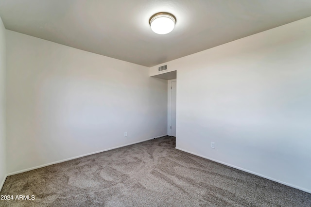 unfurnished room featuring carpet floors, visible vents, and baseboards