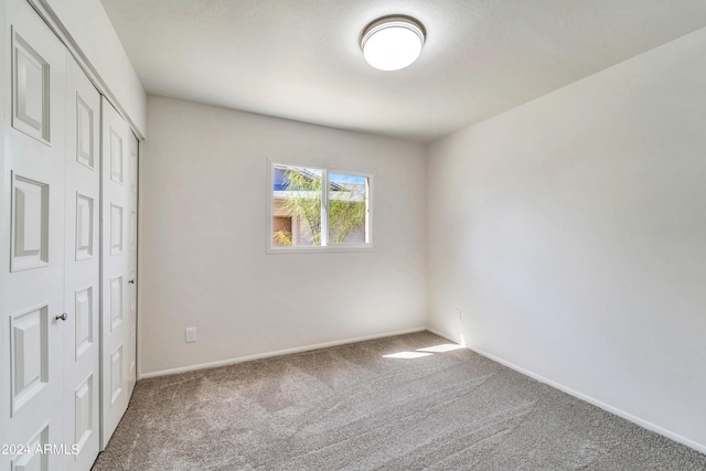 unfurnished bedroom with carpet floors, baseboards, and a closet