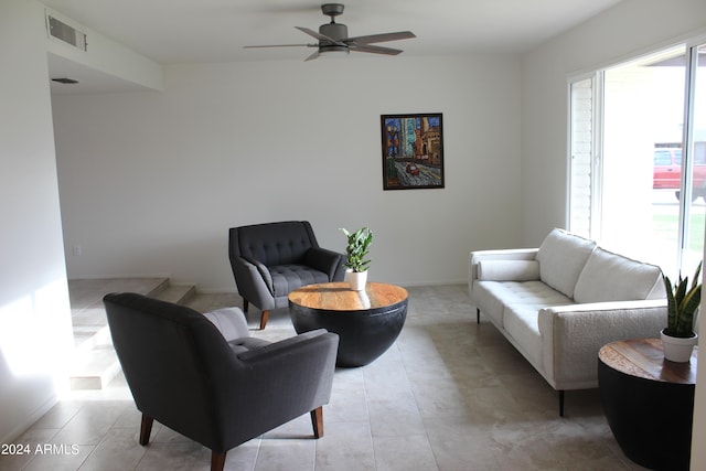 living area with ceiling fan, light tile patterned floors, visible vents, and baseboards