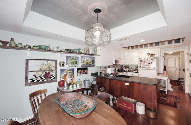 4317 N 70th St, Scottsdale, AZ 85251 - dining space with dark wood-type flooring, a raised ceiling, and a chandelier