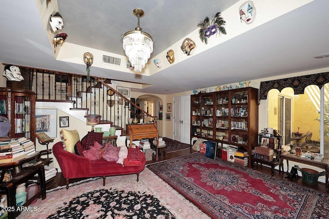 4317 N 70th St, Scottsdale, AZ 85251 - living area with arched walkways, stairs, a chandelier, a tray ceiling, and wood finished floors