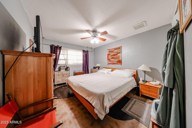 bedroom featuring visible vents, ceiling fan, and a textured ceiling
