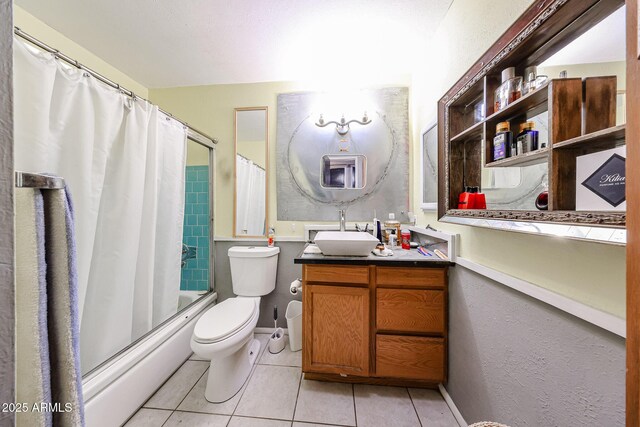 bathroom featuring baseboards, toilet, vanity, shower / tub combo with curtain, and tile patterned flooring