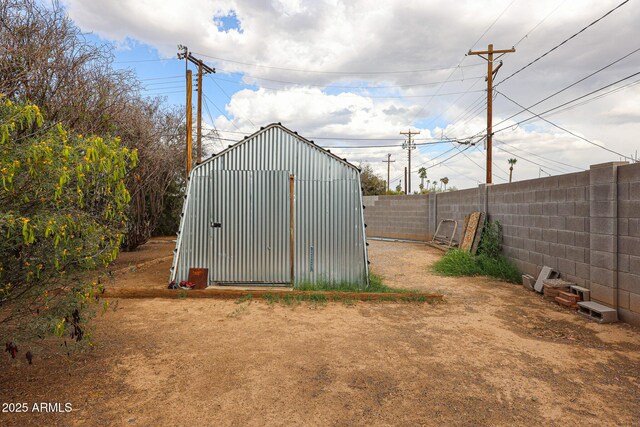 view of outdoor structure featuring an outbuilding and fence