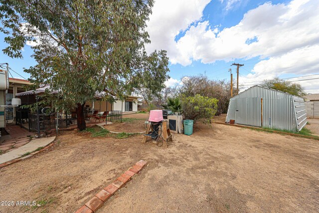 view of yard featuring an outbuilding and an outdoor structure