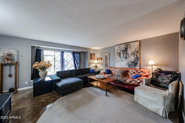 living area with baseboards, finished concrete floors, and a textured ceiling