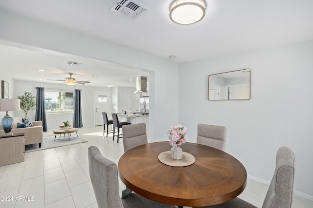 tiled dining area featuring ceiling fan and sink