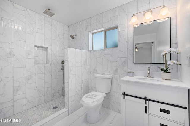 bathroom featuring tile walls, toilet, ceiling fan, tiled shower, and large vanity