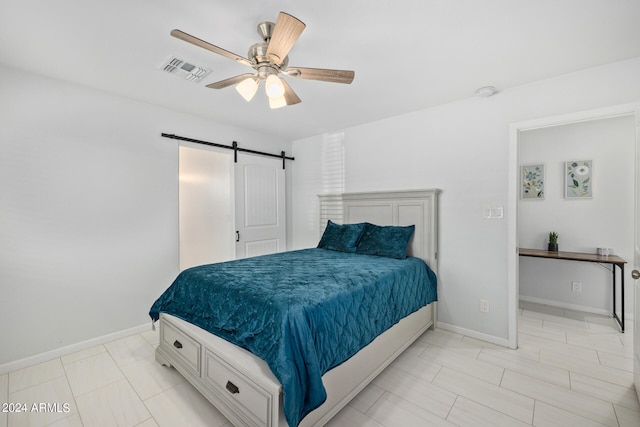 bedroom with a barn door, ceiling fan, and light tile flooring