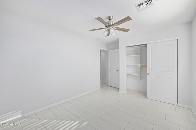 unfurnished bedroom with light tile flooring, a closet, and ceiling fan