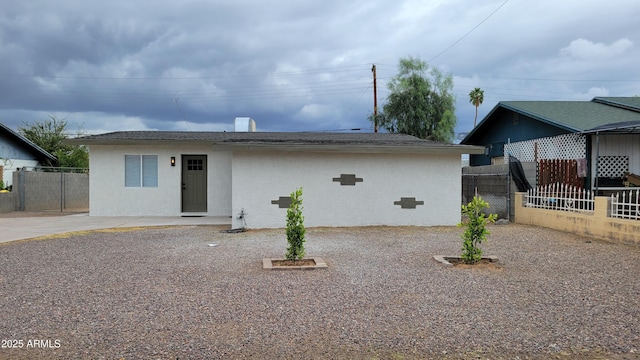 view of front of house featuring fence and stucco siding