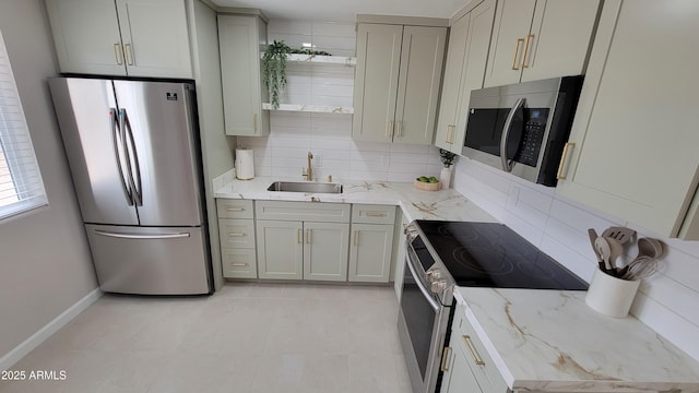 kitchen featuring appliances with stainless steel finishes, a sink, tasteful backsplash, open shelves, and baseboards