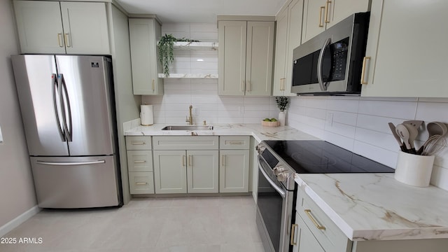 kitchen featuring appliances with stainless steel finishes, a sink, tasteful backsplash, gray cabinets, and light tile patterned floors