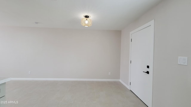 unfurnished room with baseboards