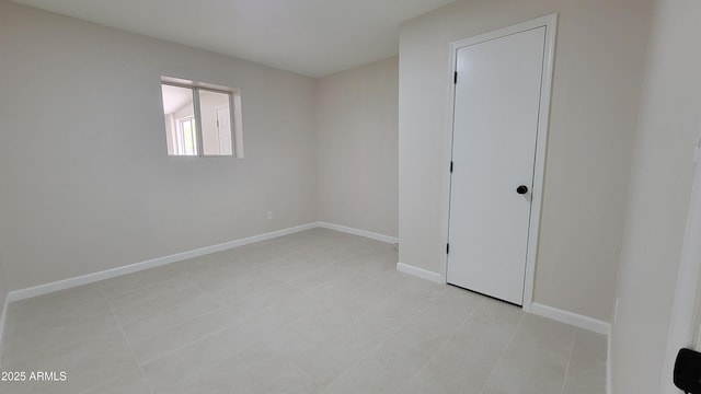 unfurnished room featuring baseboards