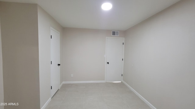 unfurnished room with baseboards and light tile patterned flooring