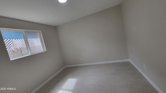 empty room featuring tile patterned floors and baseboards