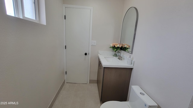 half bathroom with vanity, toilet, baseboards, and tile patterned floors
