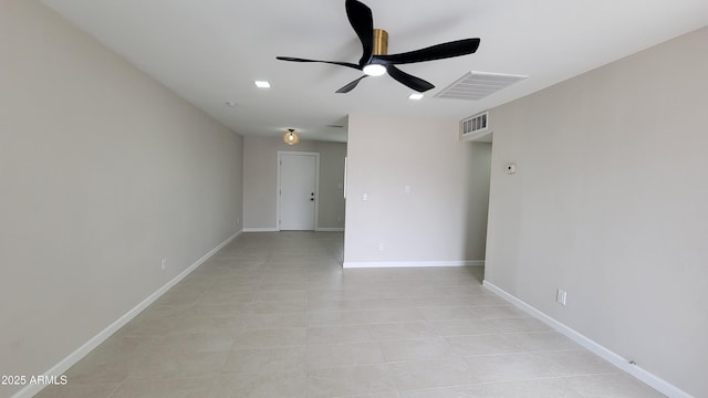 empty room with ceiling fan, light tile patterned flooring, and baseboards