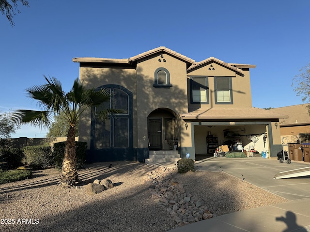 mediterranean / spanish home featuring a tiled roof, stucco siding, an attached garage, and concrete driveway