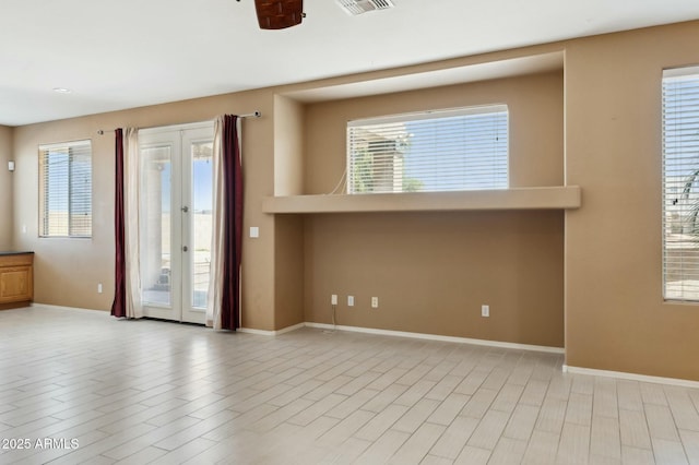 empty room featuring french doors, baseboards, a healthy amount of sunlight, and wood finished floors