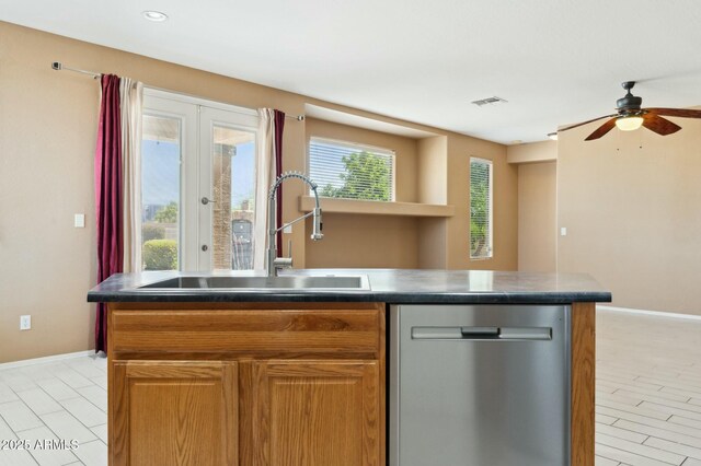 kitchen with french doors, stainless steel dishwasher, a center island with sink, a sink, and visible vents