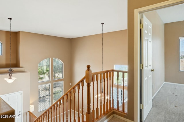 staircase featuring baseboards, carpet, and an inviting chandelier
