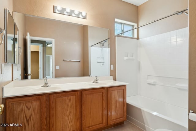 bathroom featuring shower / washtub combination, double vanity, and a sink