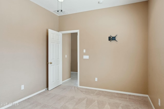 spare room featuring baseboards, light colored carpet, and visible vents