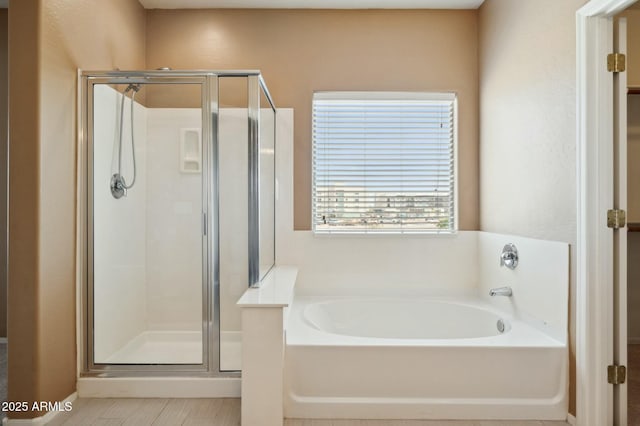 bathroom featuring a stall shower and a bath