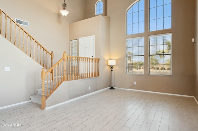 interior space featuring visible vents, wood finished floors, stairway, and a healthy amount of sunlight
