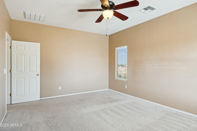 empty room featuring carpet floors, baseboards, visible vents, and ceiling fan