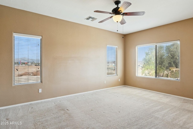 carpeted spare room with a ceiling fan, baseboards, and visible vents