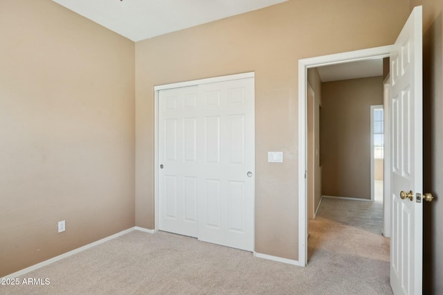 unfurnished bedroom with baseboards, carpet flooring, and a closet