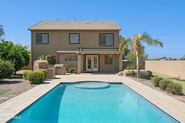 rear view of property featuring stucco siding, french doors, a fenced backyard, exterior kitchen, and a patio area